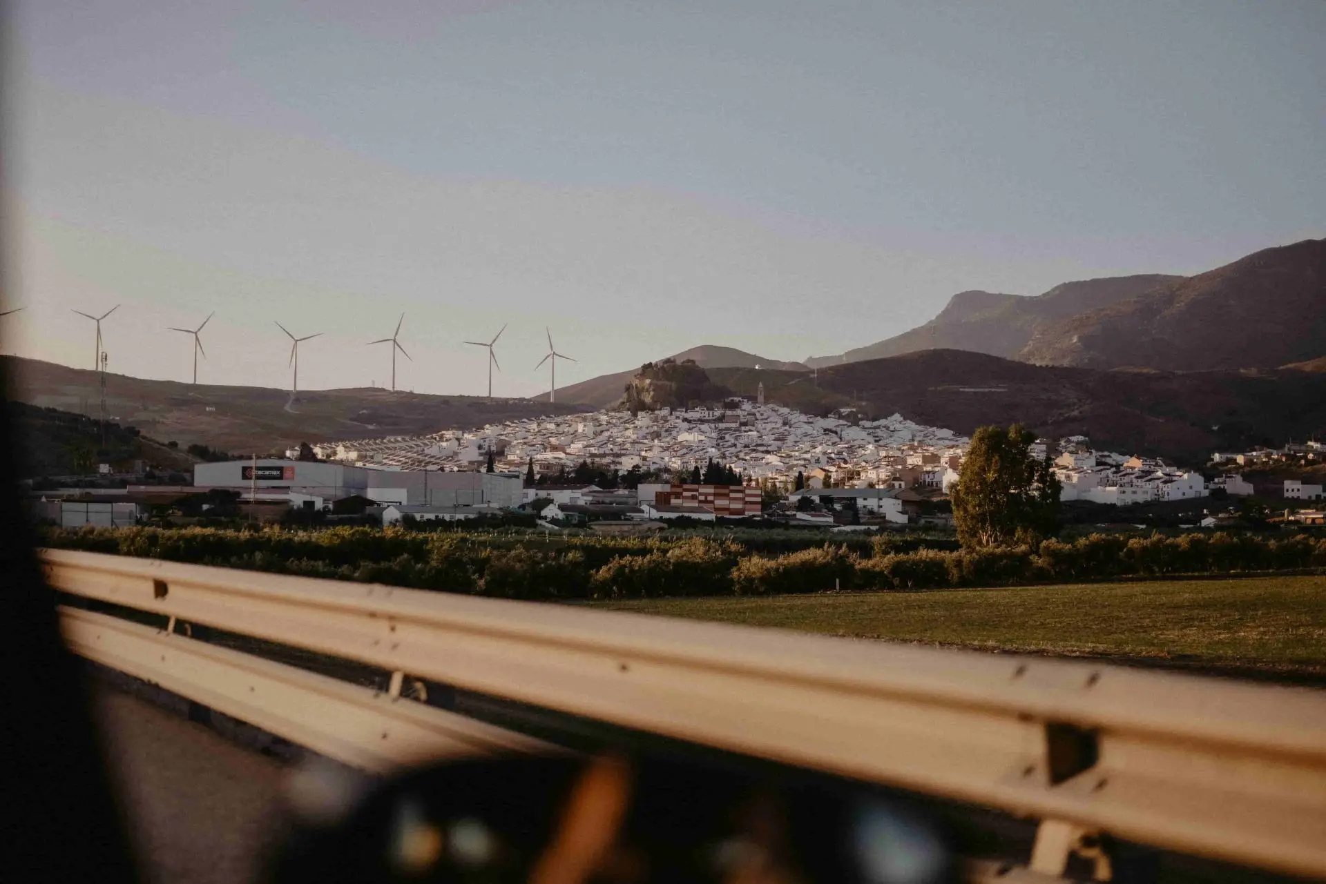 View from a car driving past a Spanish town with wind turbines – comparing car insurance quotes